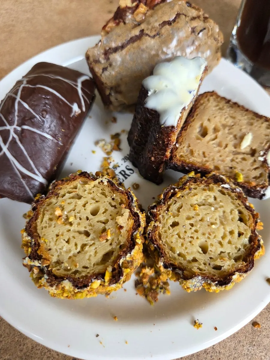 Pistachio canelé thickly coated in pistachio pieces