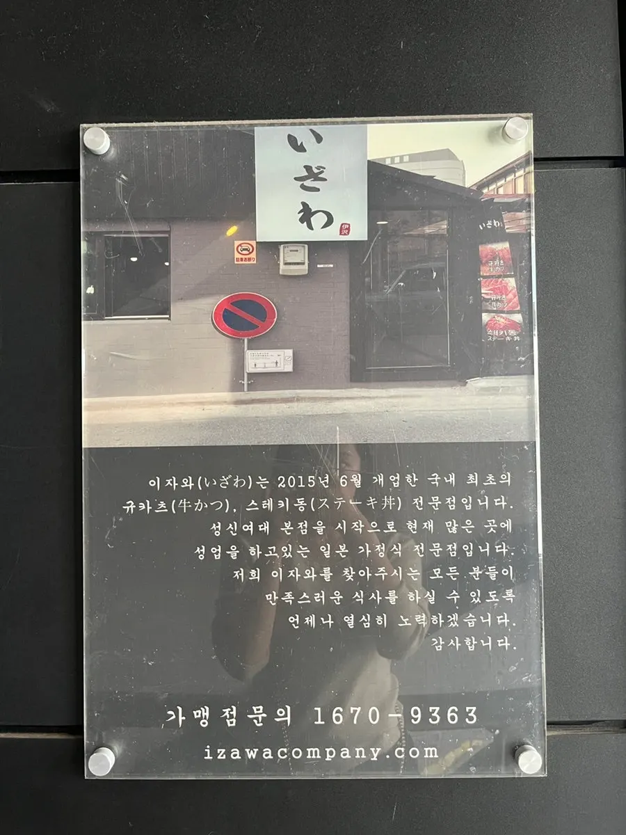 Izawa brand information sign posted beside the entrance