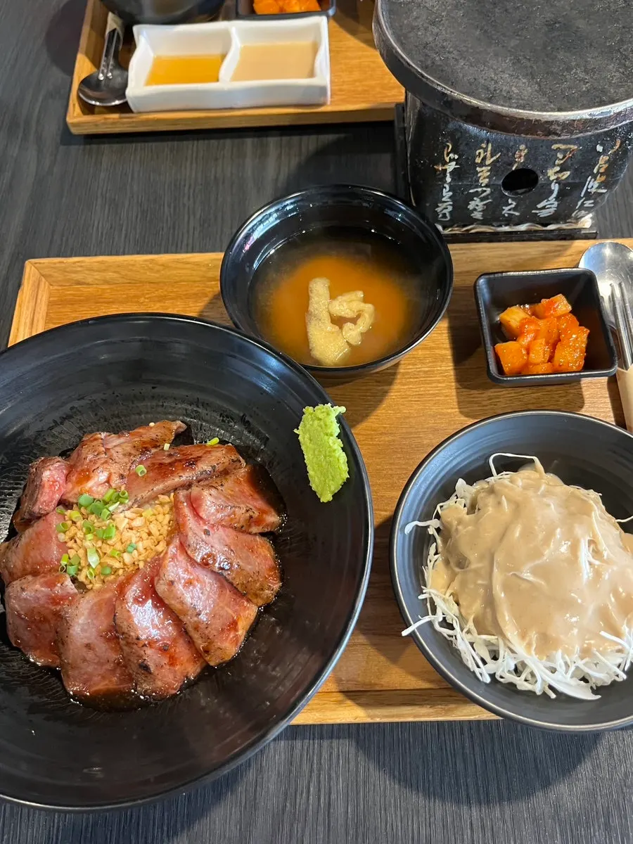 A piece of gyukatsu topped with wasabi and dipped in sauce