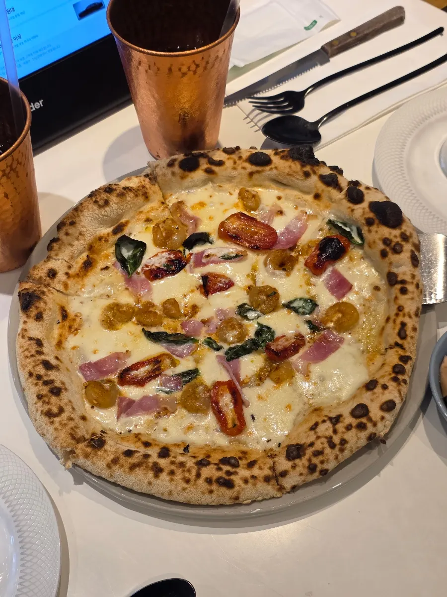 A slice of guanciale pizza showing the crust end