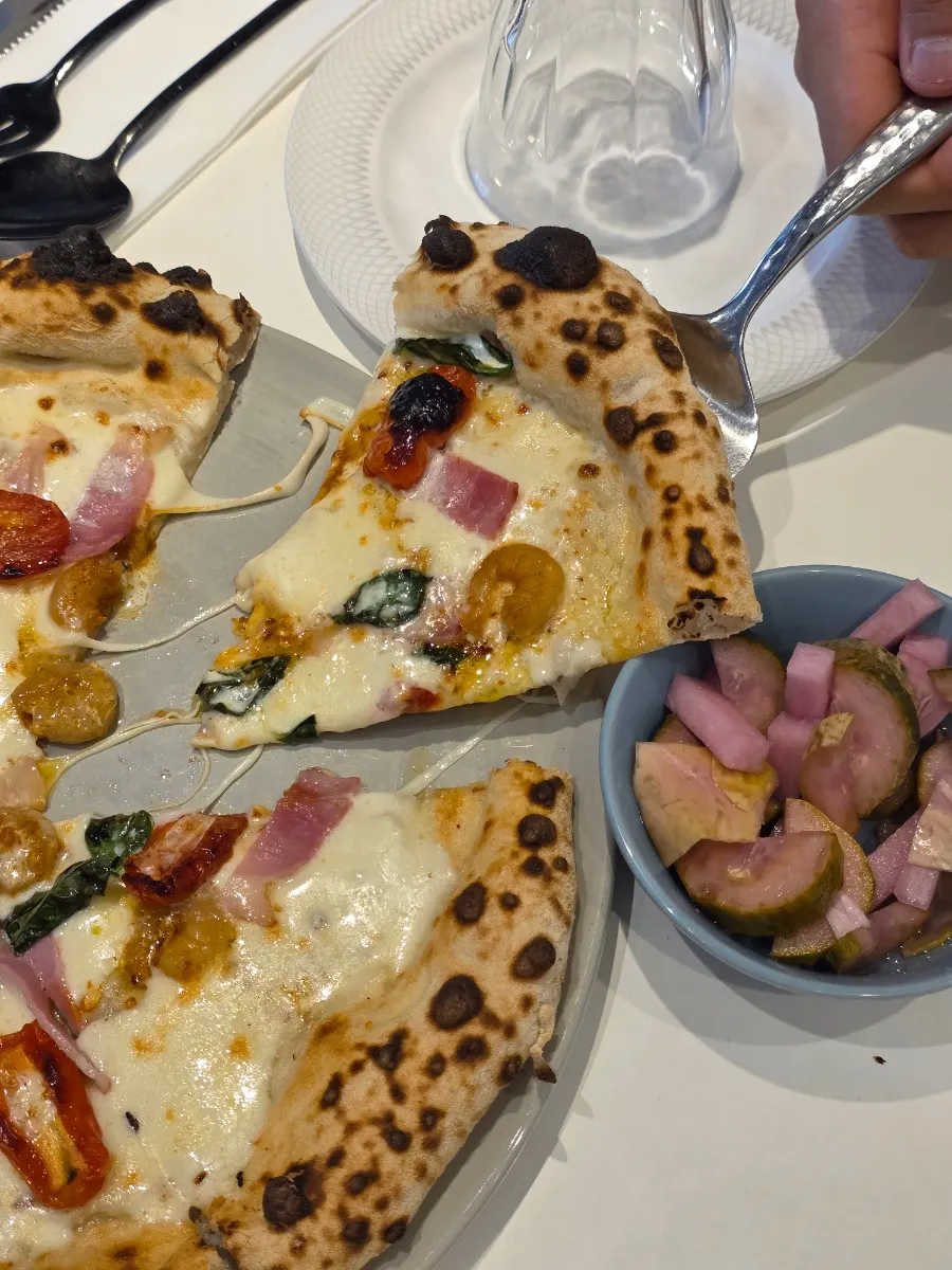 Cross-section of oak-fired pizza topped with guanciale