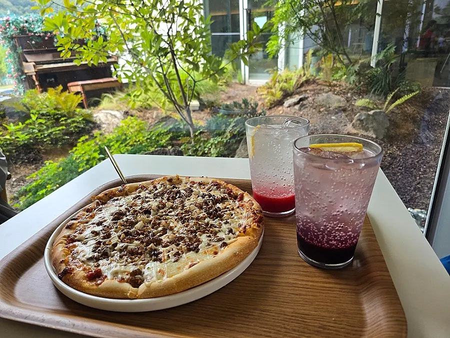 Table spread of bulgogi pizza, drinks, and castella croissant