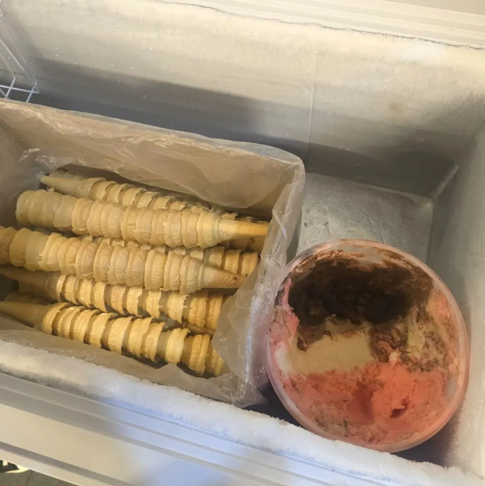Scooping strawberry, chocolate, and vanilla ice cream into a cone