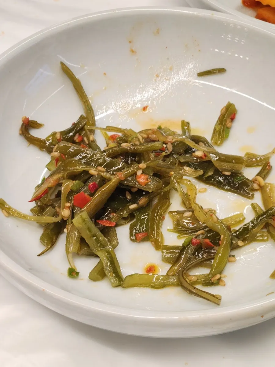 Plates of bracken namul, stir-fried seaweed stem, and other side dishes