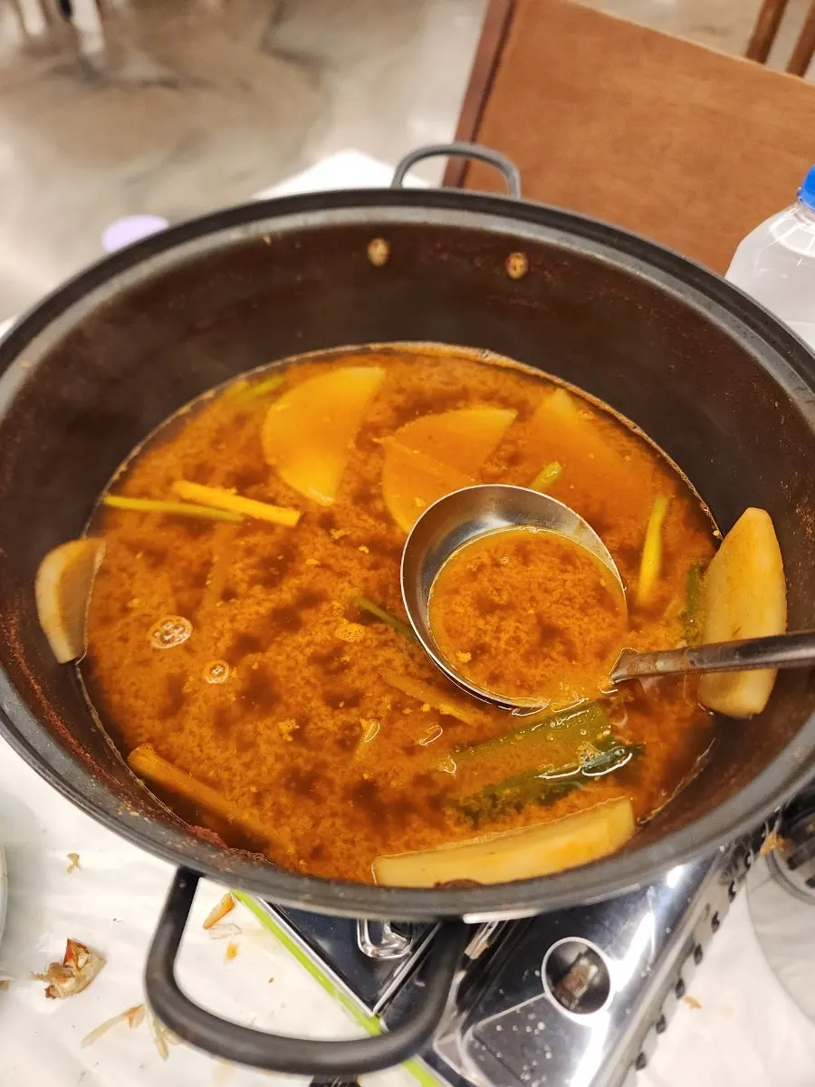 Crab soup broth and rice in a shallow bowl