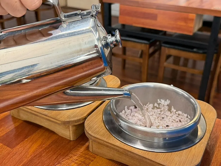 Scooping rice out from the opened hot pot lid