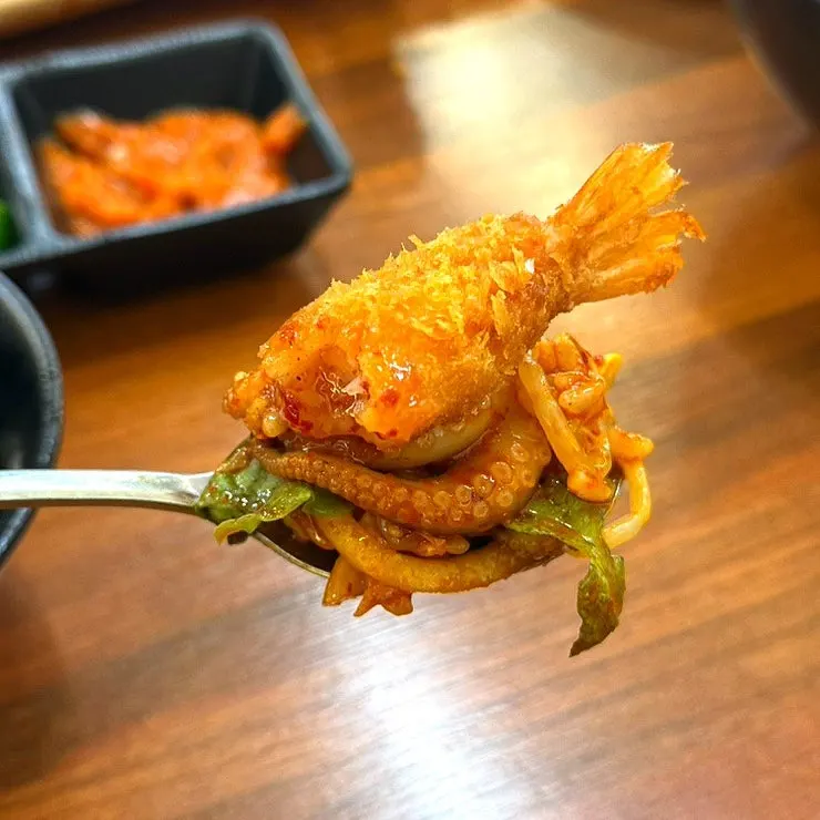Shrimp tempura served with chili sauce alongside jjukkumi
