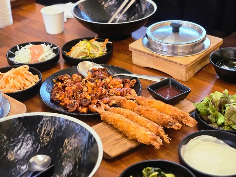 Side dishes including bean sprouts, radish salad, and cold seaweed soup