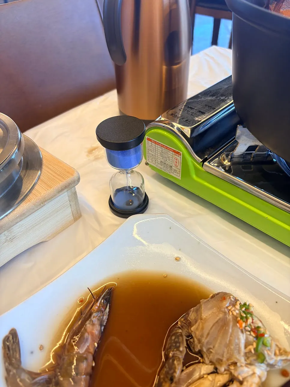 Five-minute sand timer beside the simmering crab soup