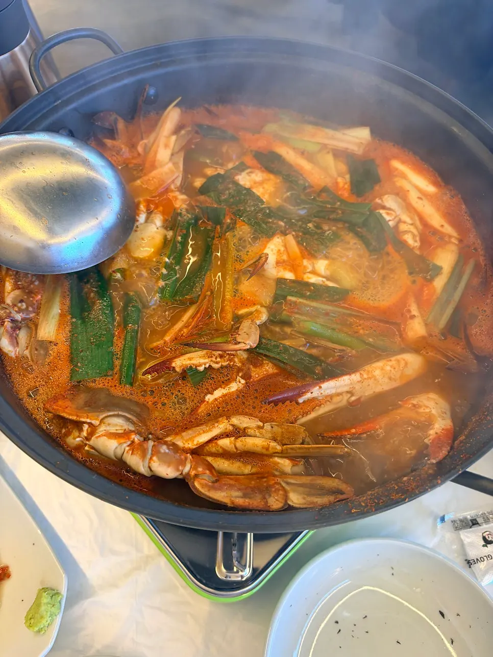 A meat-packed crab lifted out of the broth