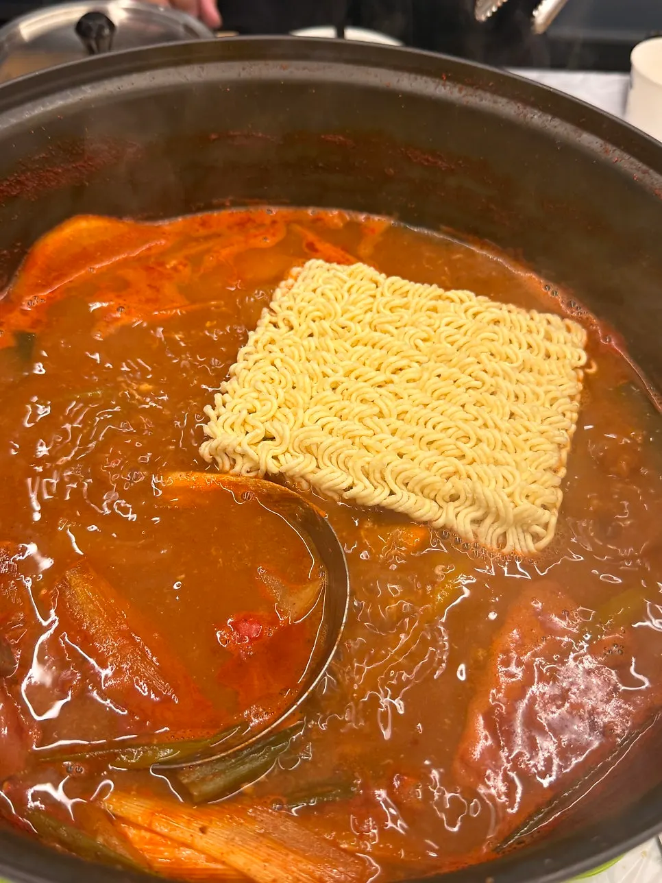 Scooping out the remaining contents of the crab soup pot