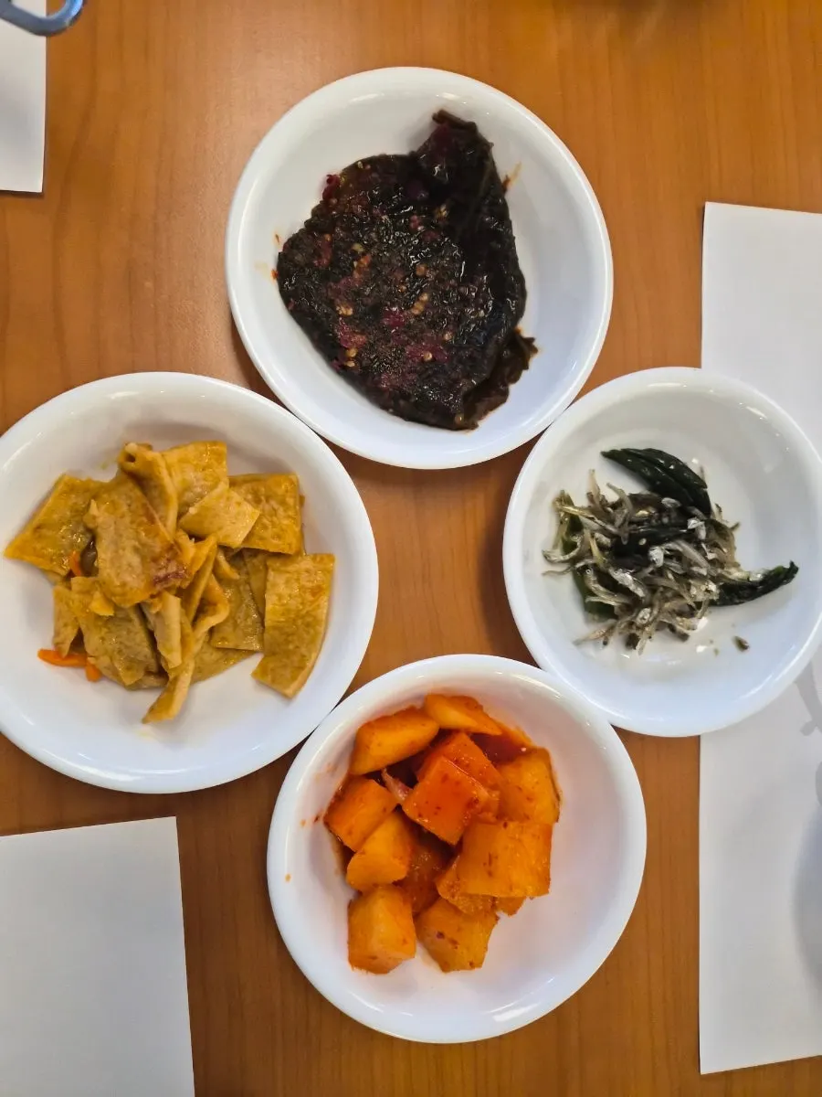 Table setting with side dishes served alongside milbok soup at Bogi-o Boguk