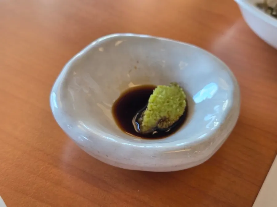 Pufferfish meat dipped in soy-wasabi sauce