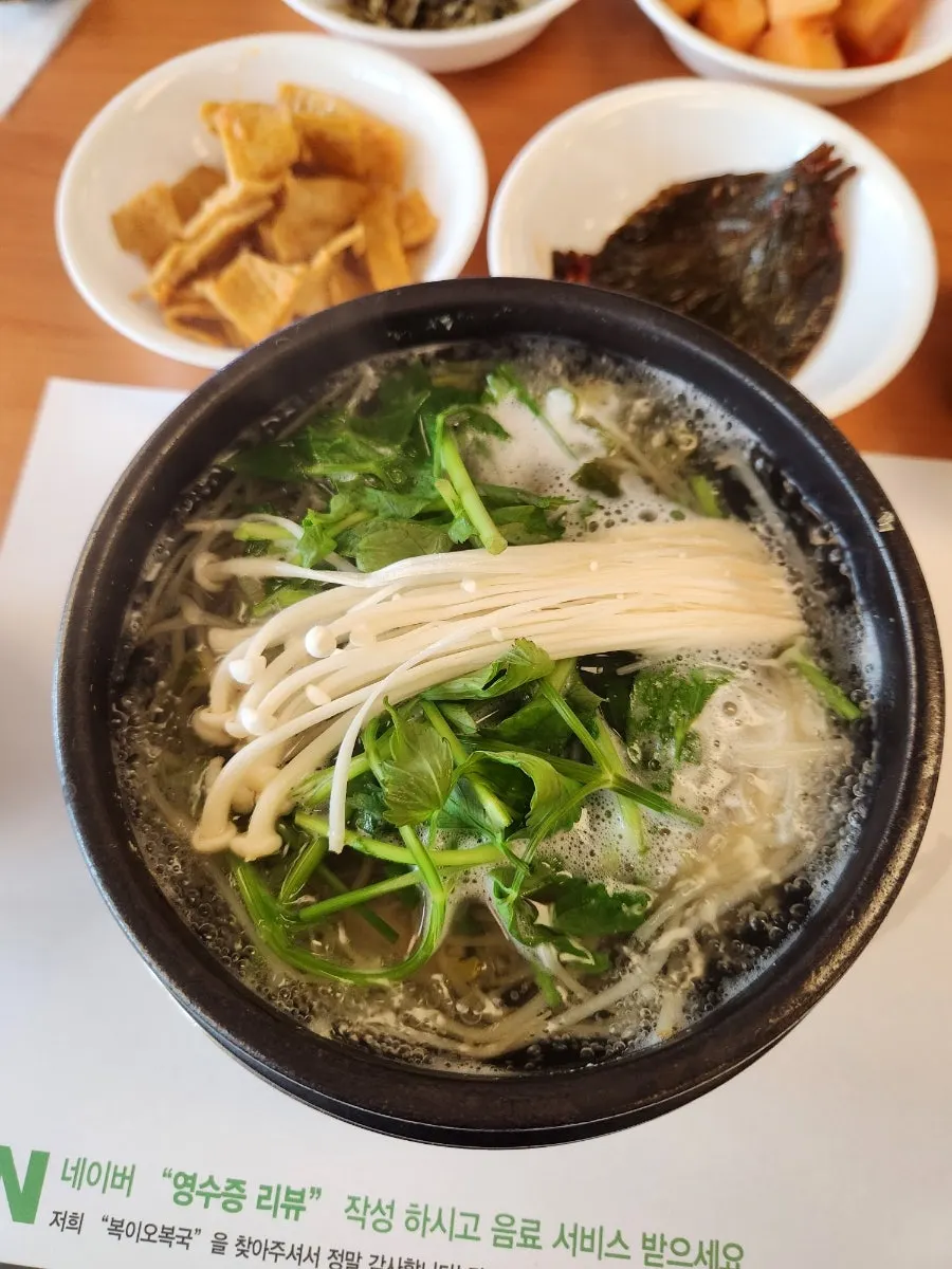 Milbok clear soup topped with enoki mushrooms and water dropwort