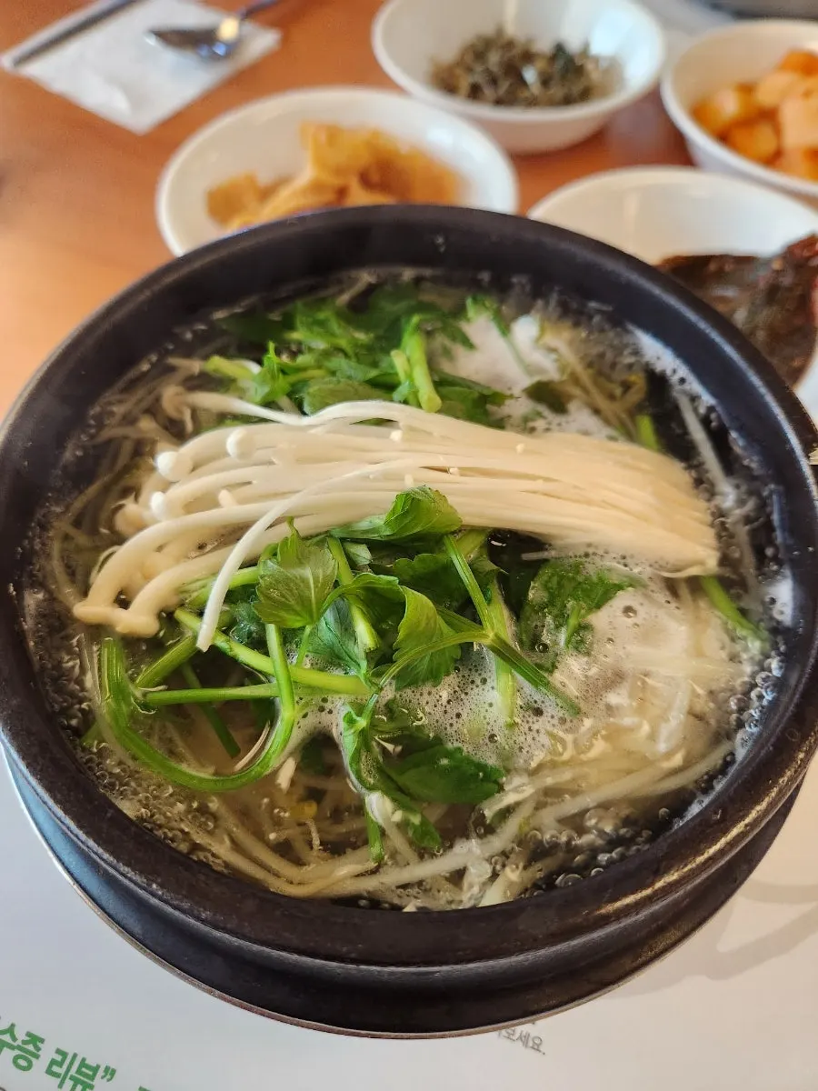 Clear pufferfish soup broth full of bean sprouts