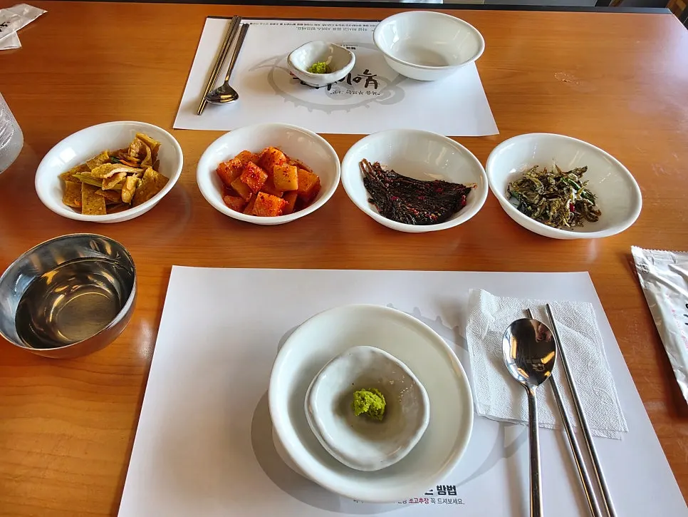 A full spread of milbok jiri topped with water celery and bean sprouts