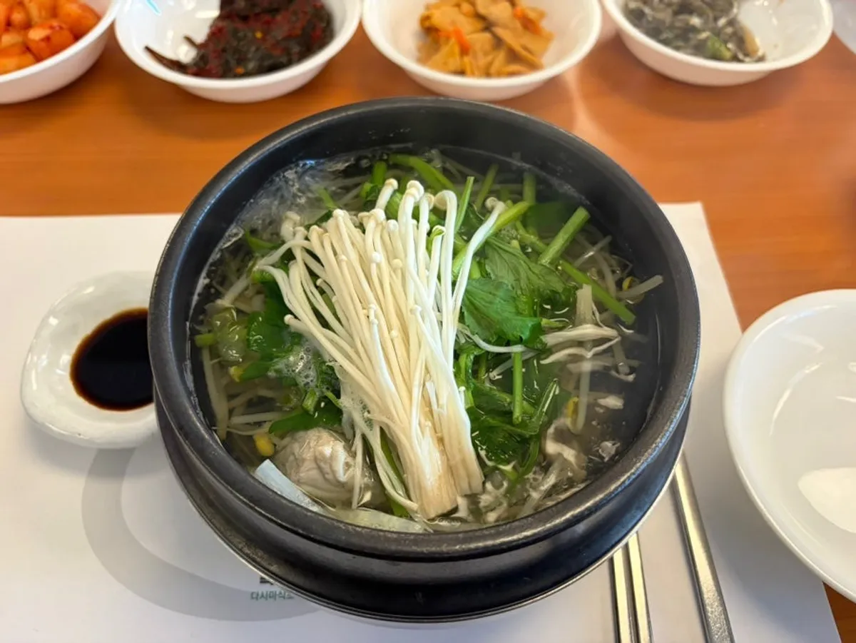 Clear pufferfish soup bubbling in an earthenware pot