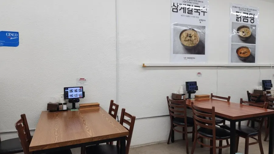 우드 톤 테이블이 놓인 매장 내부