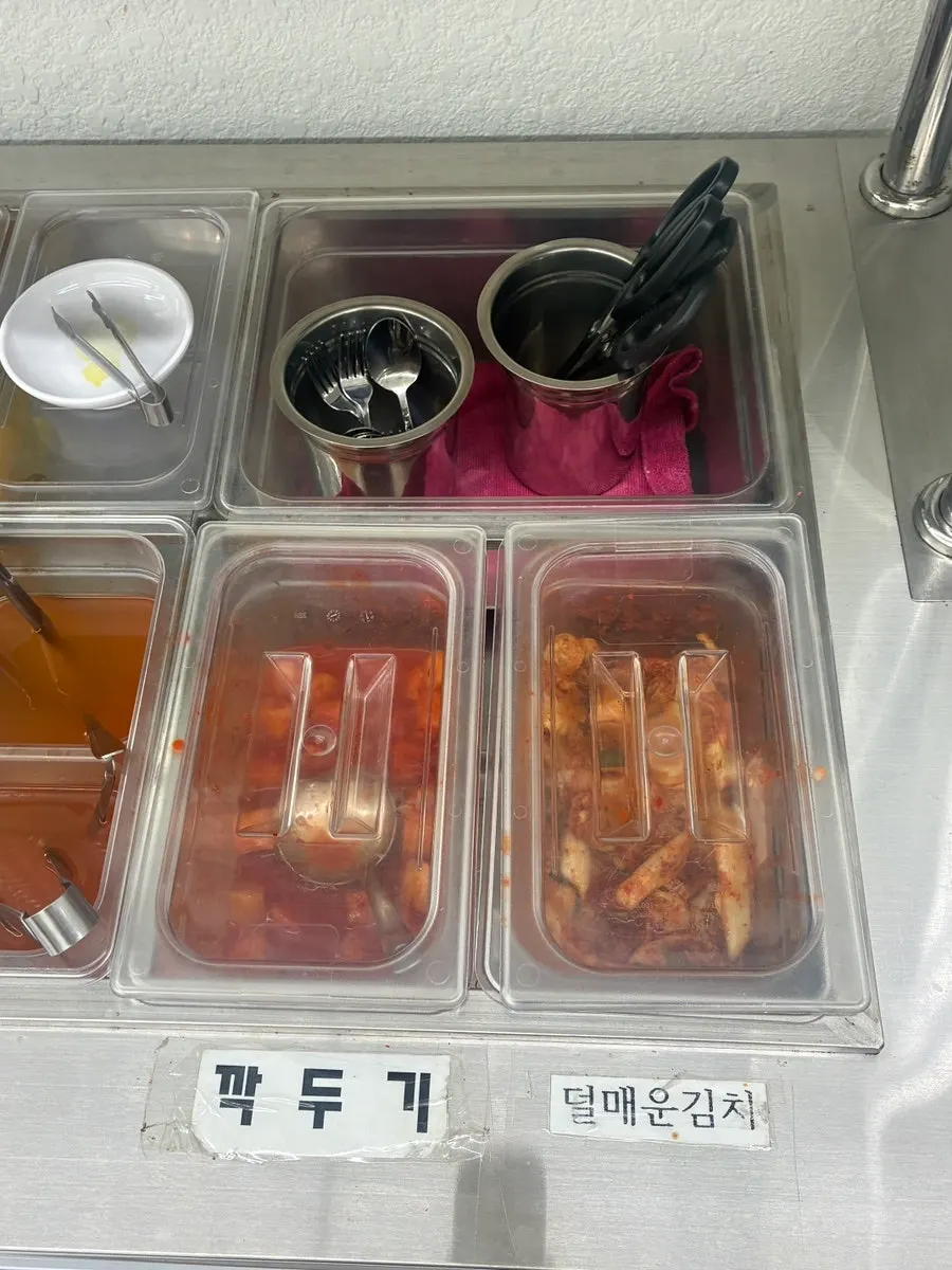 매운김치와 깍두기가 담긴 셀프바 반찬 코너