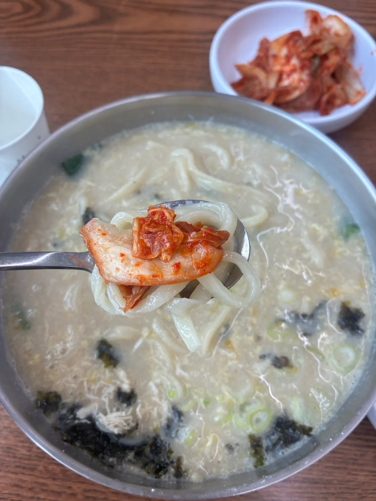 젓가락으로 들어 올린 칼국수 면발과 닭고기