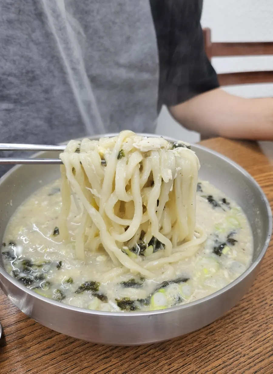 노란 계란 고명이 더해진 닭칼국수 국물