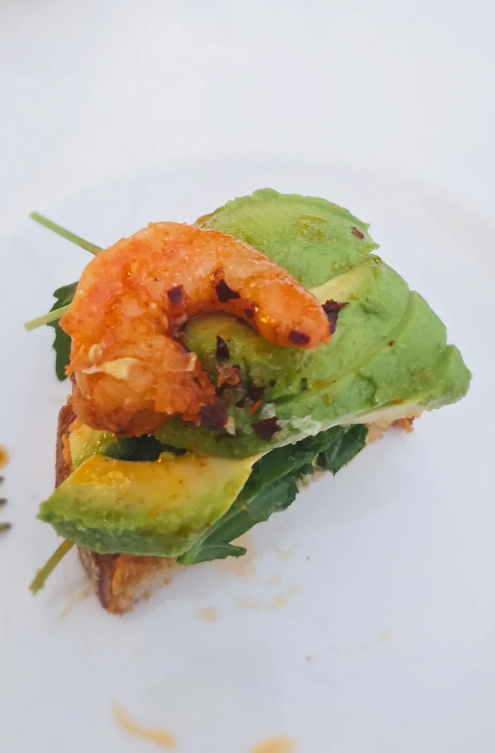 Sandwich generously filled with arugula and avocado