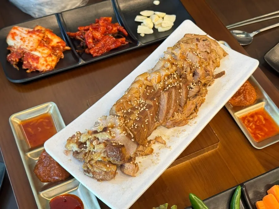 젓가락으로 집어 든 보쌈 한 점