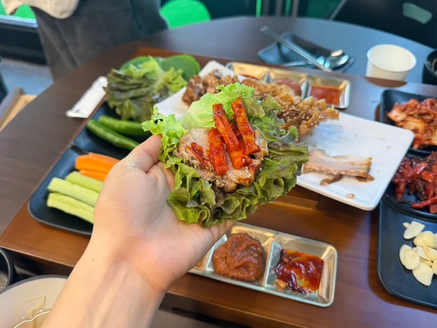 쌈채소에 보쌈과 김치를 올린 모습