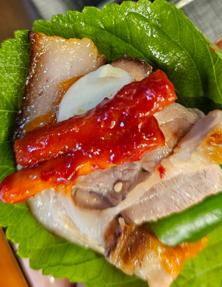 Lettuce wrap with jokbal, garlic, and dried radish strips