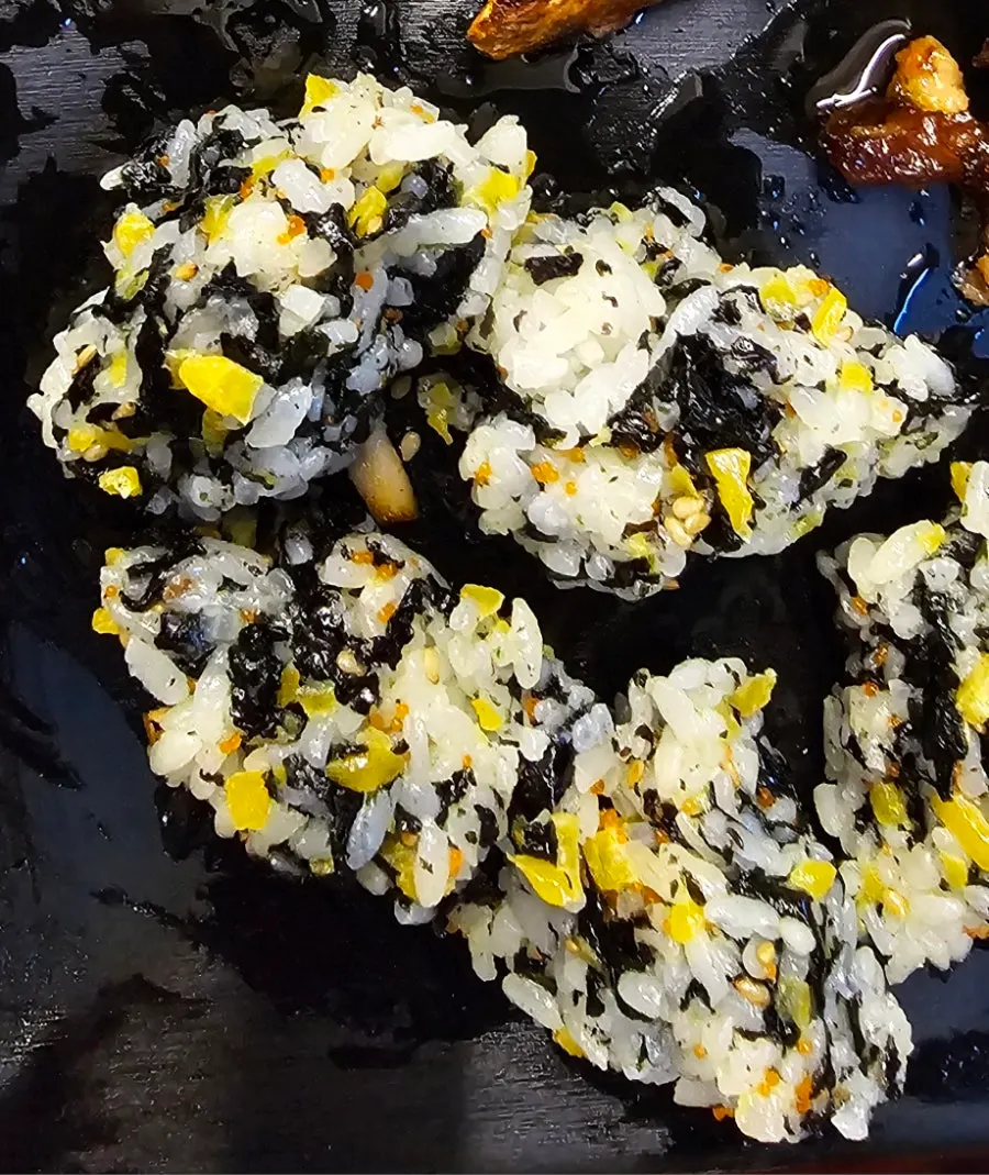 Hands rolling seaweed rice balls