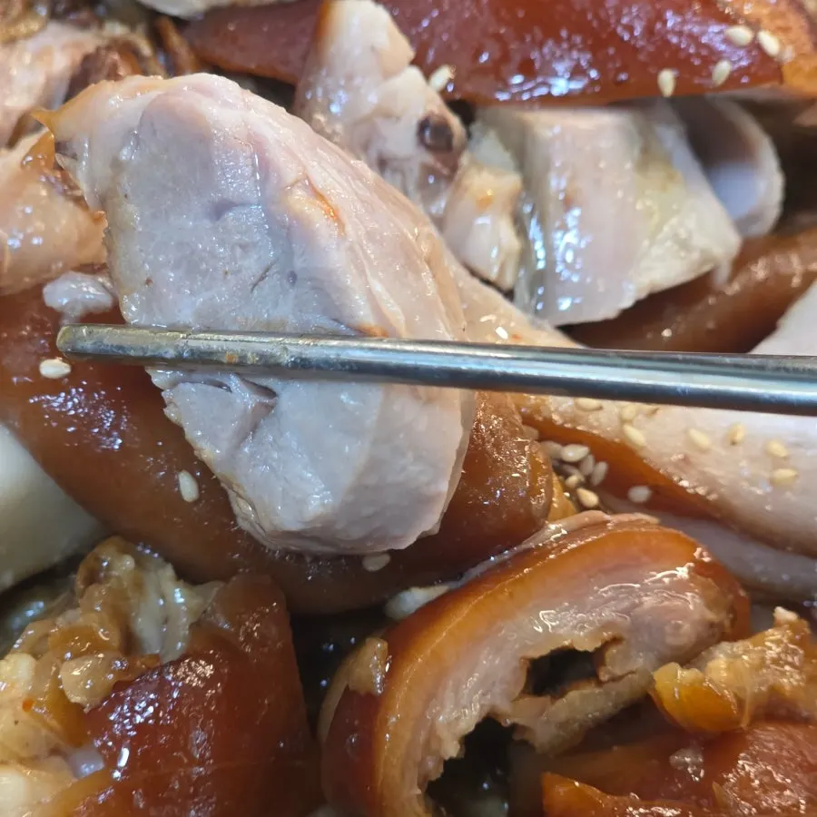 A bite of jokbal topped with kimchi