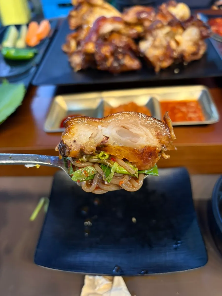 A piece of jokbal placed on top of makguksu