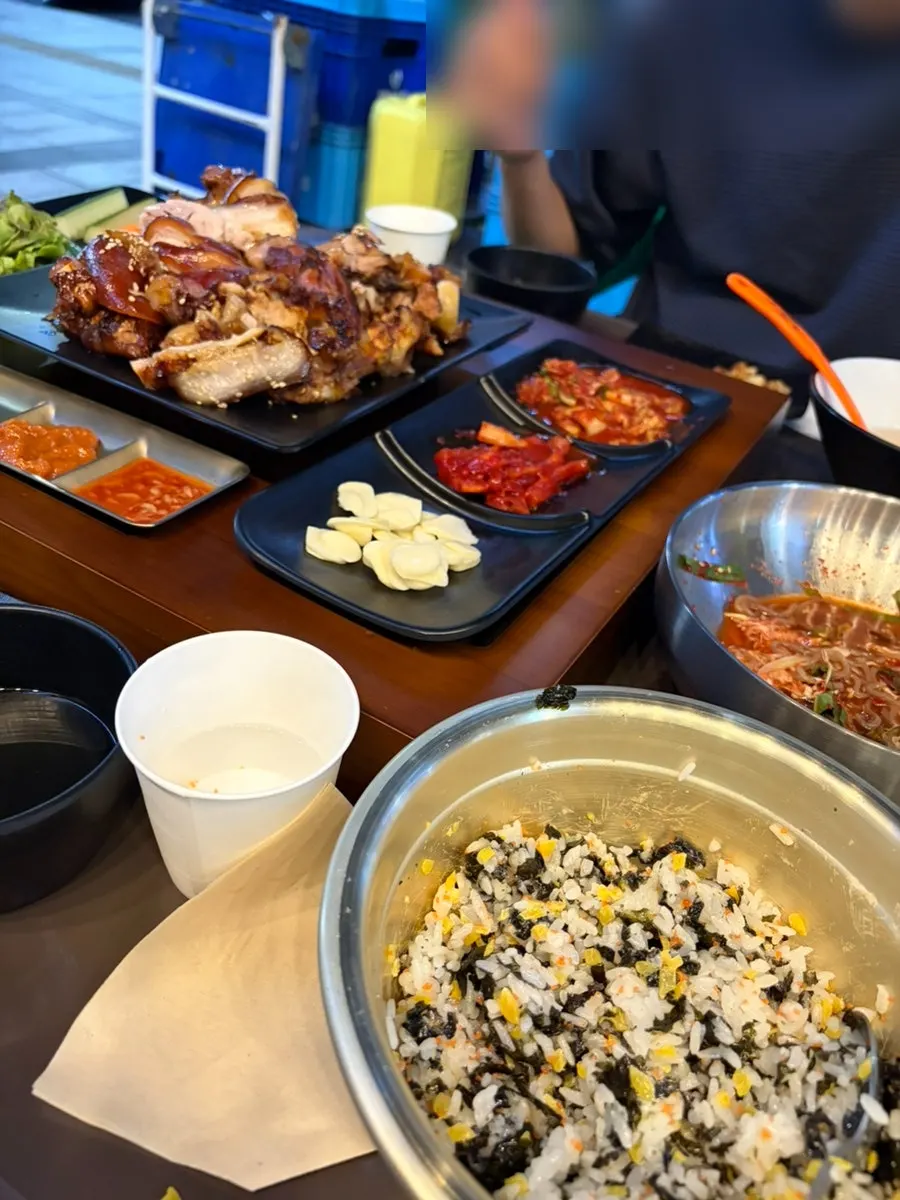 Full table spread with jokbal, makguksu, and rice ball