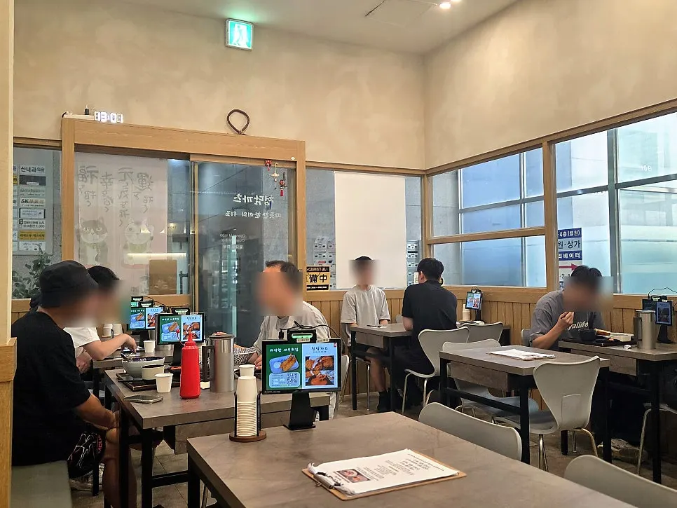 Tables filled with weekend lunch customers inside Cheongdam Kkatsu