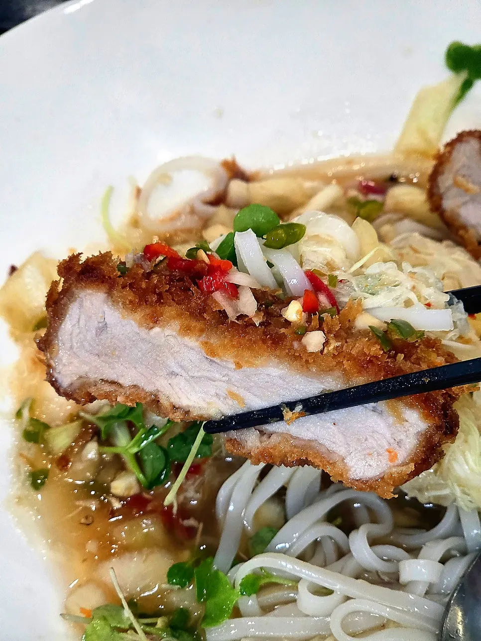 A bite of Aqua Pork Cutlet with bún chả sauce