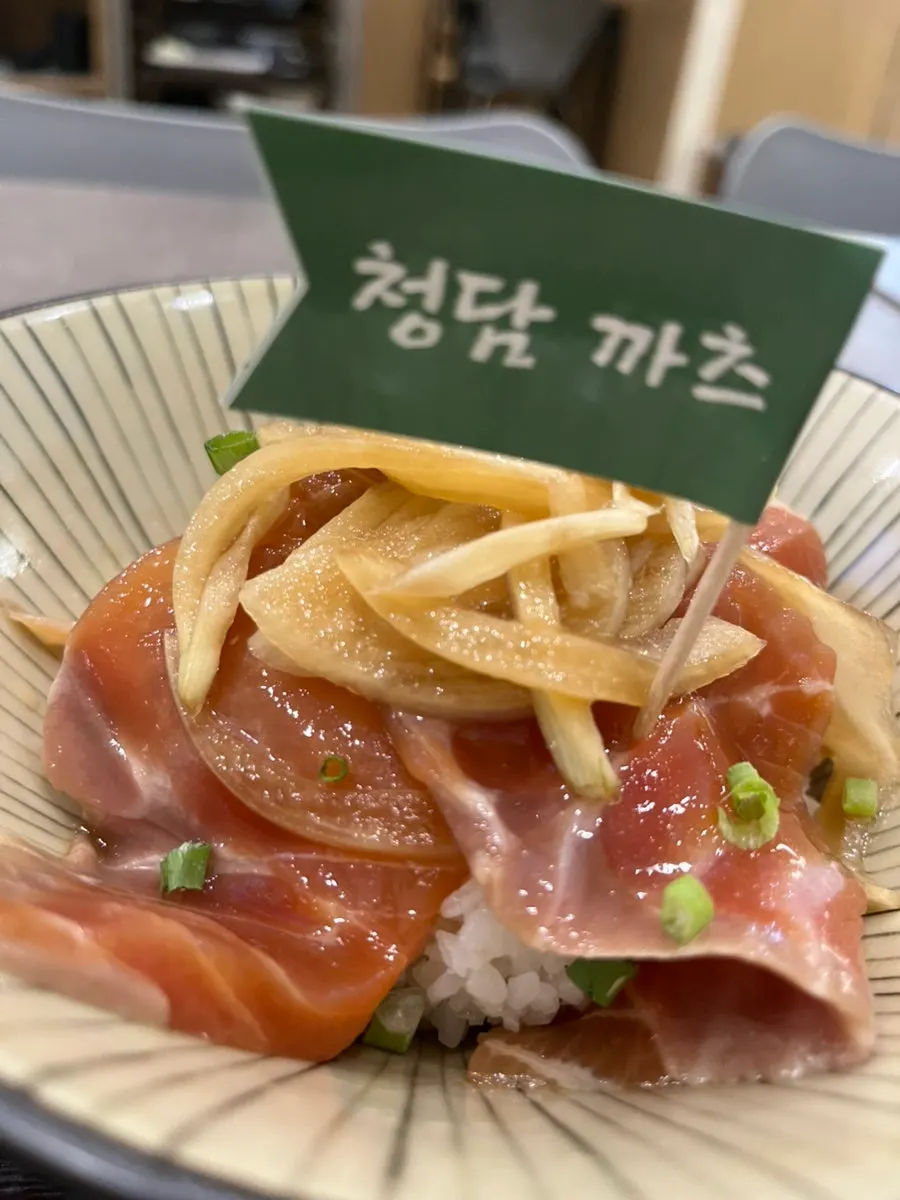 Onion served alongside the salmon jang rice bowl