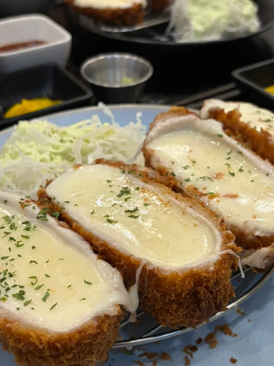 매운소스를 곁들인 치즈 까츠 한 조각