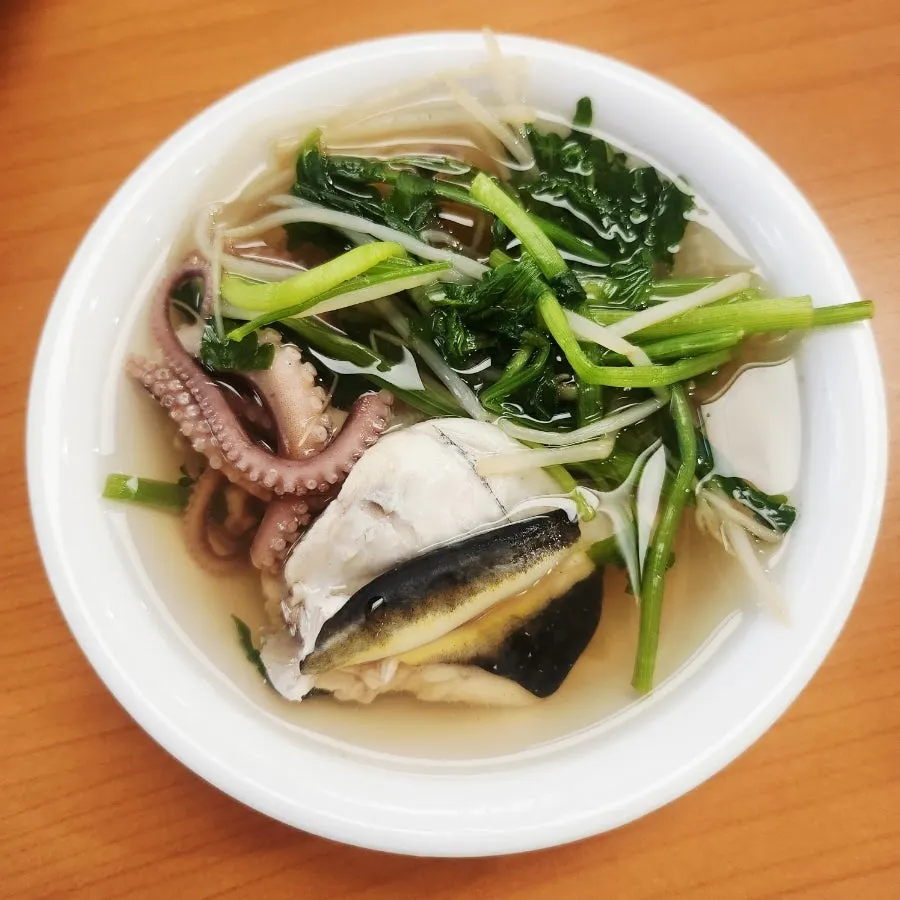 Close-up of the clear broth in the live octopus pufferfish soup