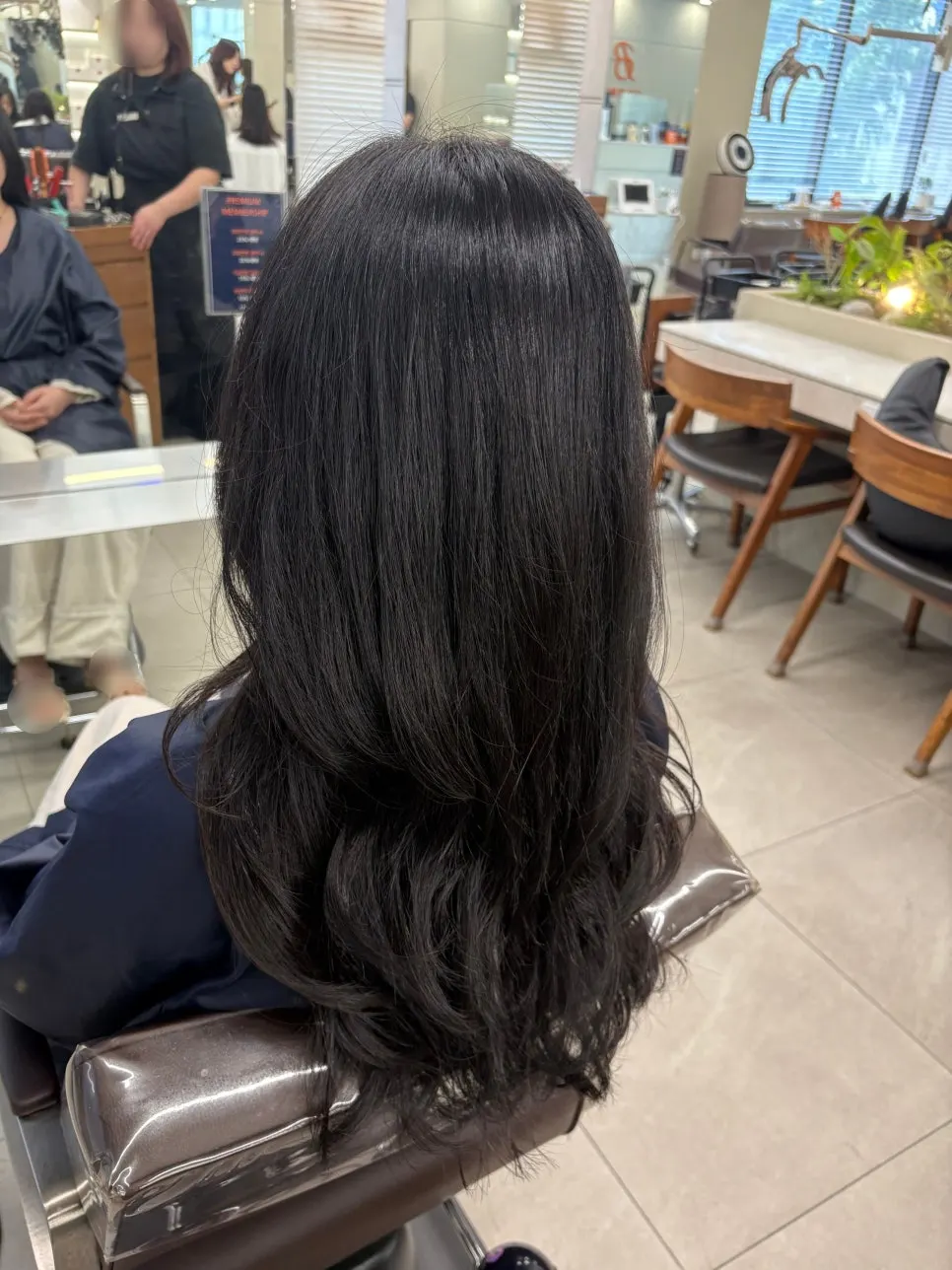 Layered cut and straight perm being applied