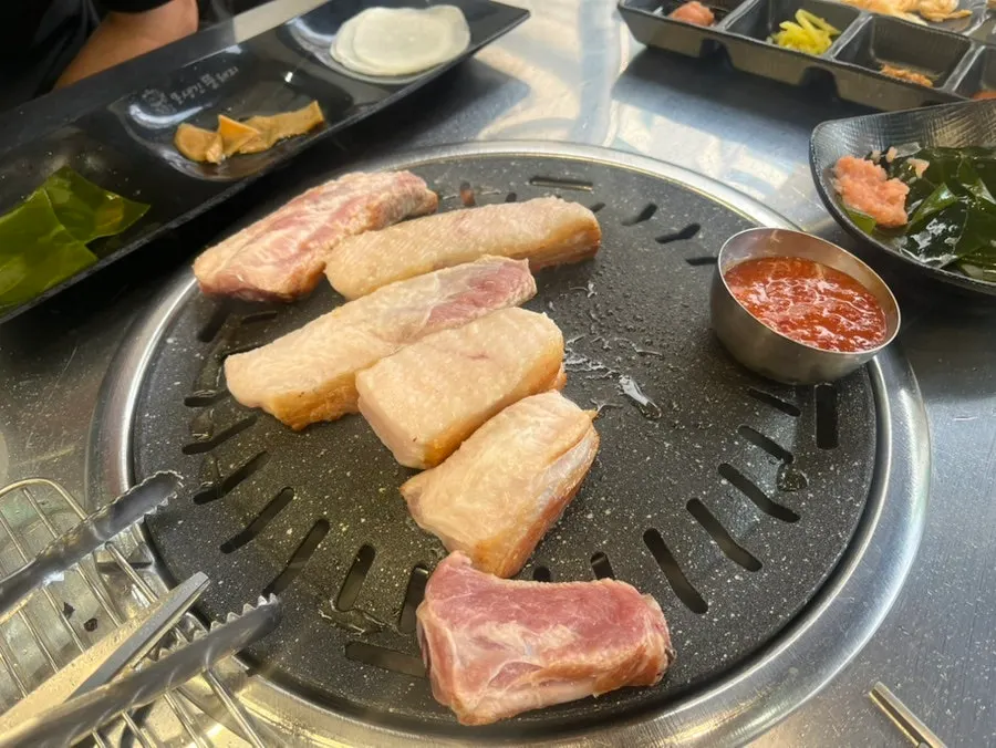 직원이 생갈비살을 가로로 잘라 굽는 모습