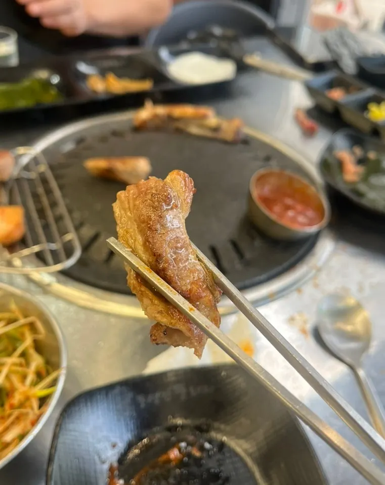 고기와 비빔국수를 함께 싸 먹는 모습
