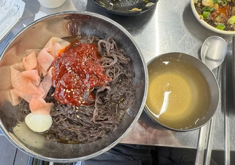 Bibim naengmyeon topped with boiled egg and pickled radish
