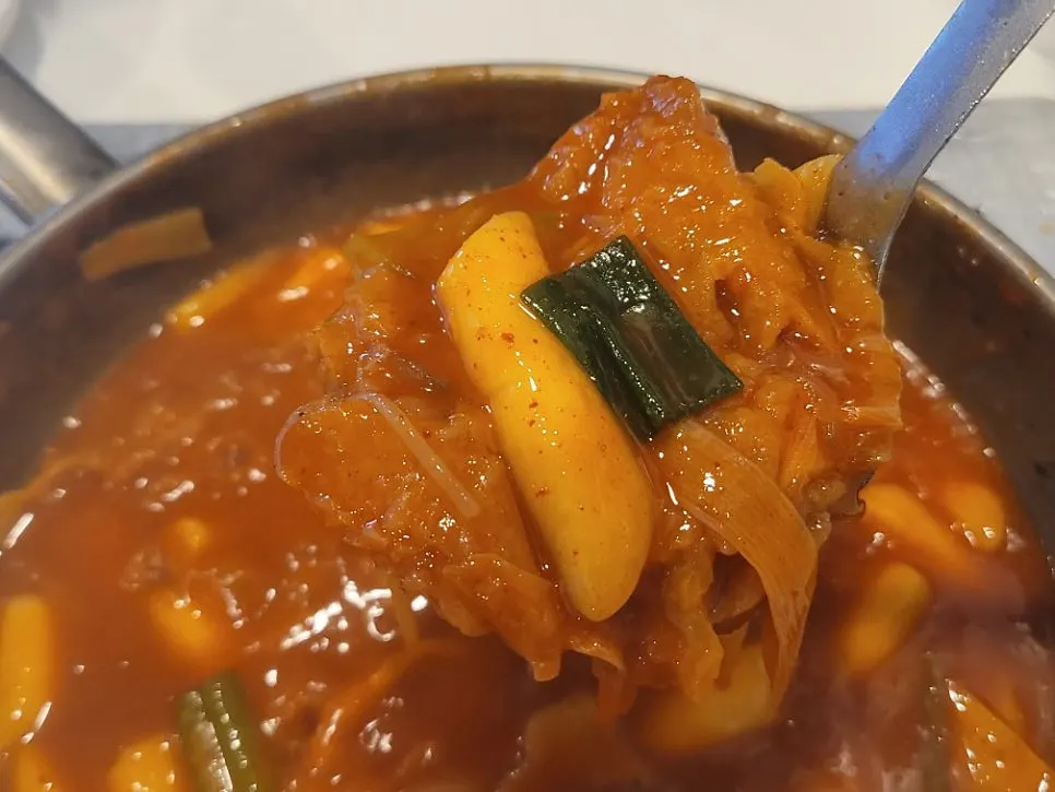 Rice cake, fish cake, and cabbage lifted by ladle