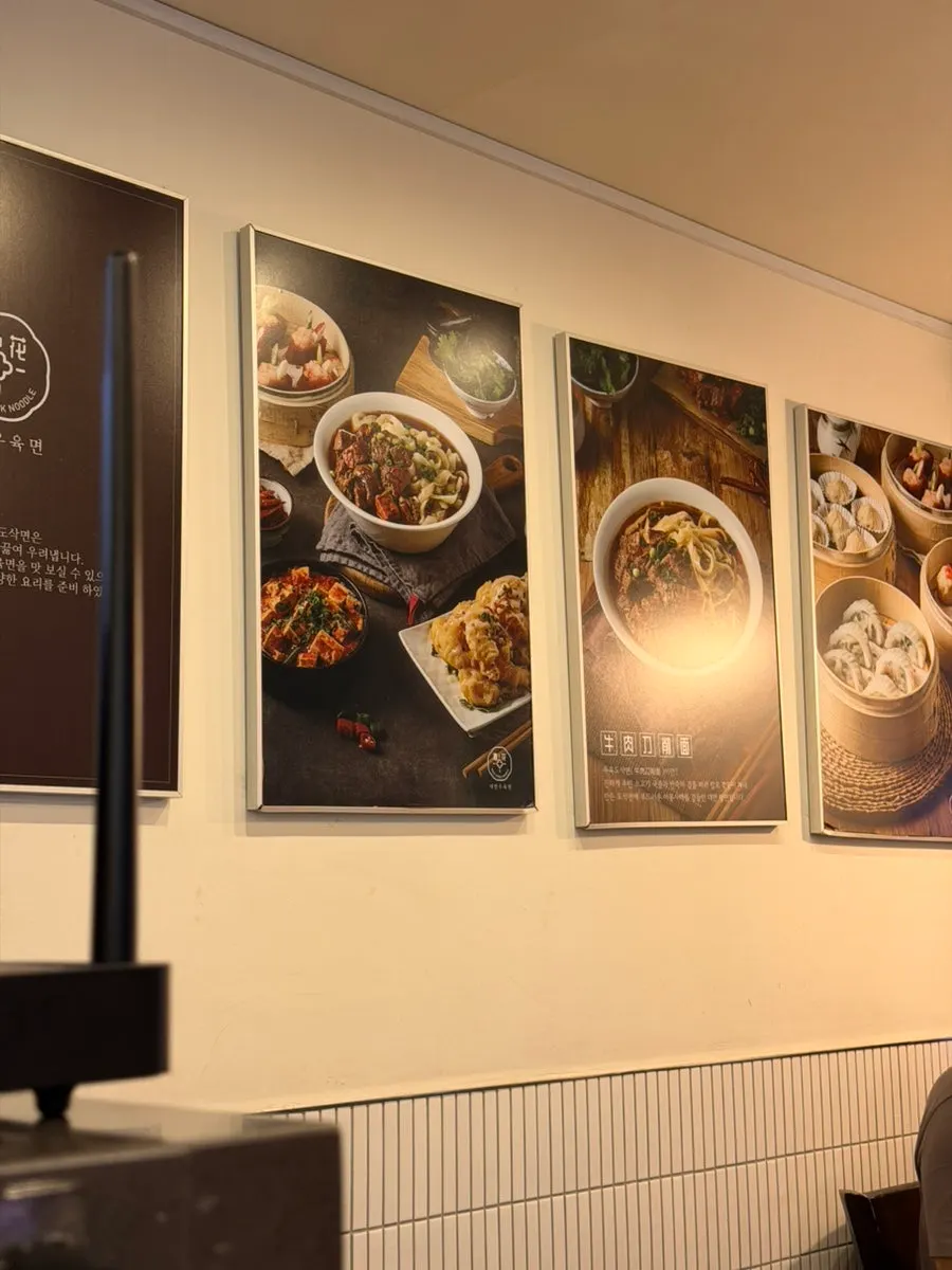 Menu photos hanging on the wall of Cheonghwa Uyuk Dosakmyeon
