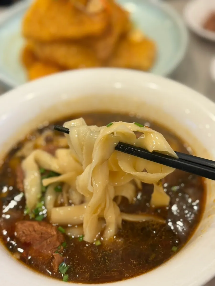 Close-up of the beef noodle broth and toppings
