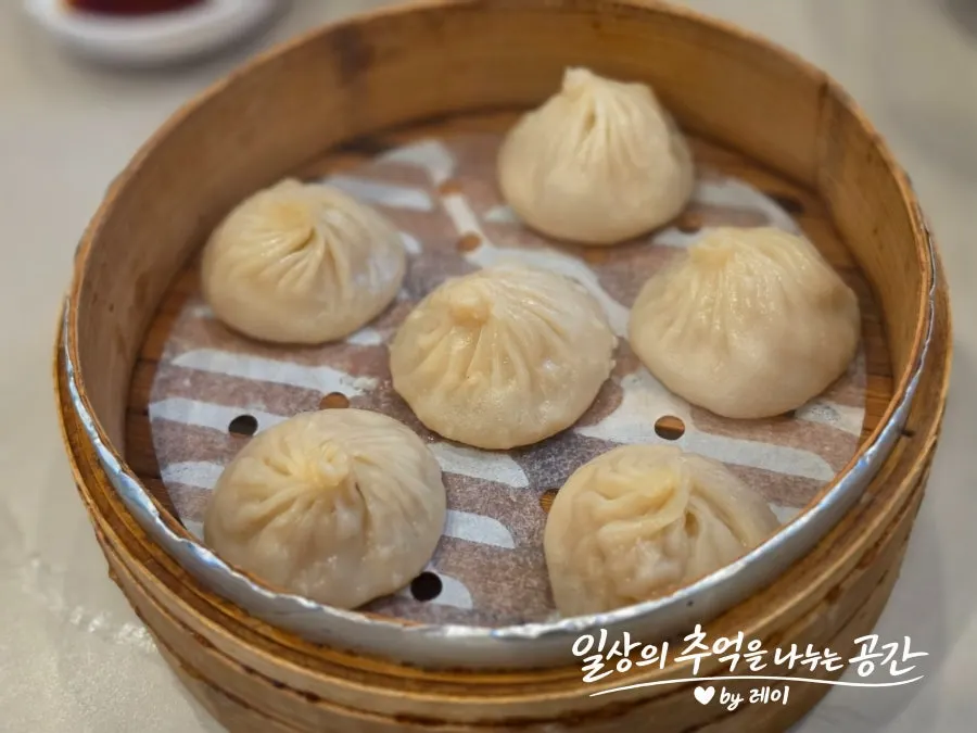 Six xiaolongbao served in a steamer basket