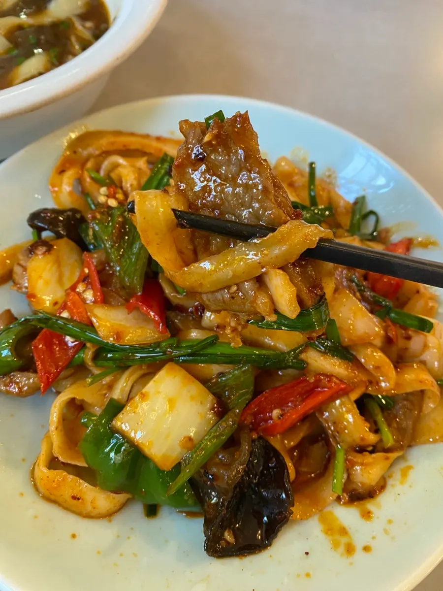 Lifting a bite of the stir-fried beef noodles