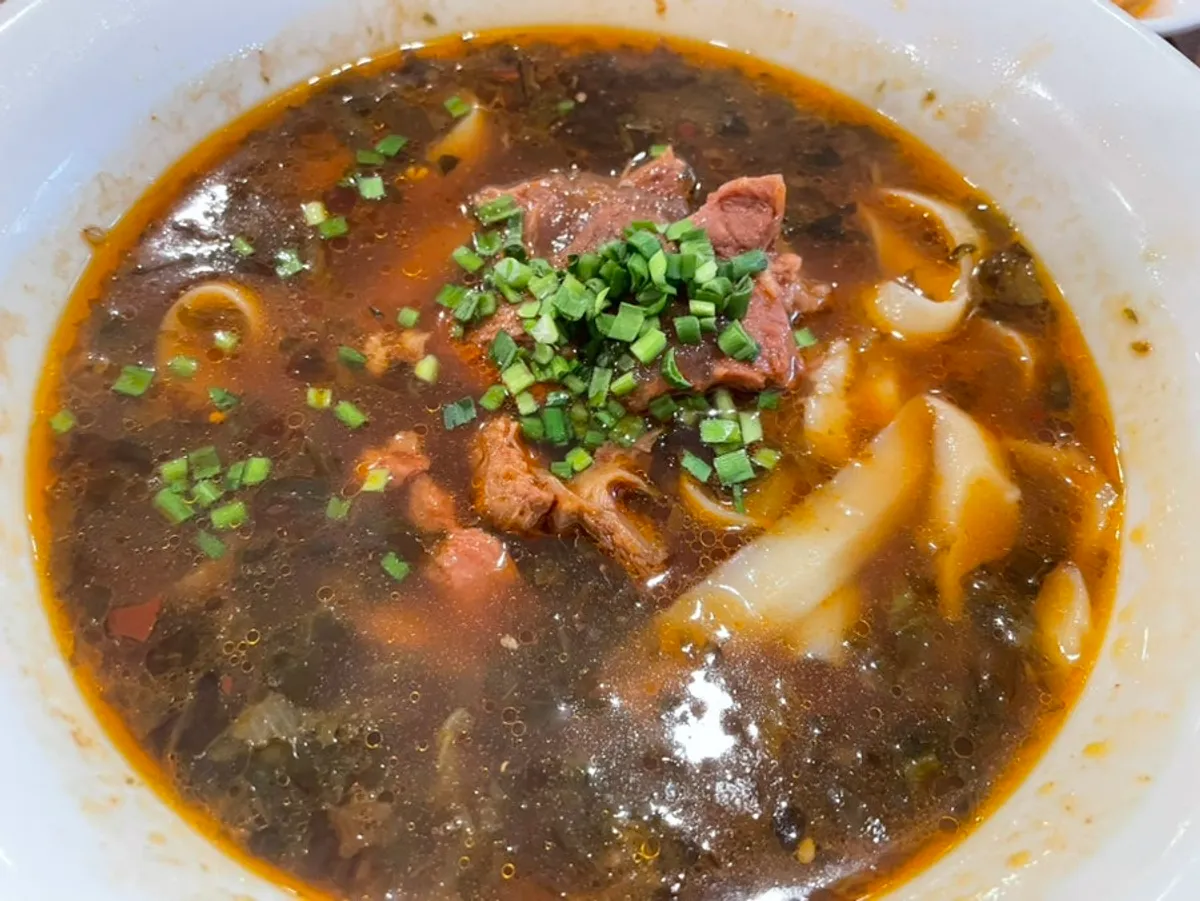 A spoonful of yuxiang pork bowl piled high with pork