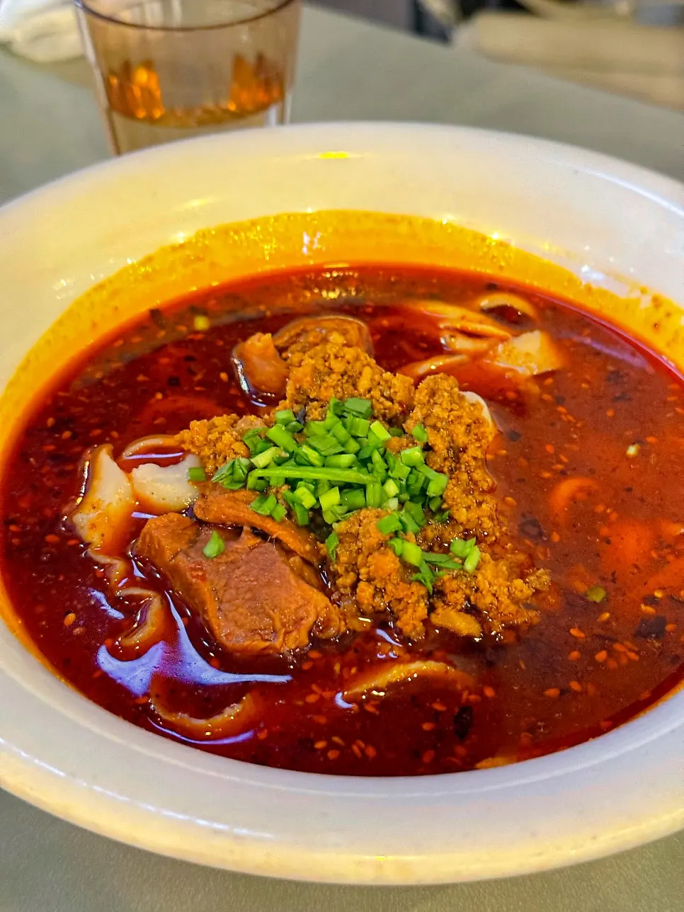 A bowl of Sichuan-style beef dosakmyeon in red mala broth
