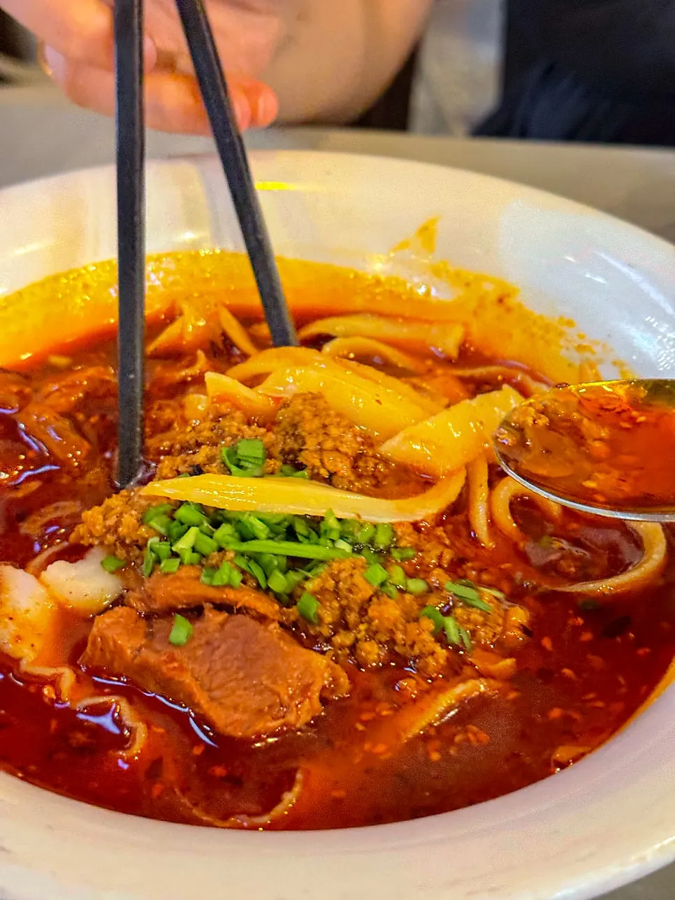 Chewy dosakmyeon noodles lifted with chopsticks